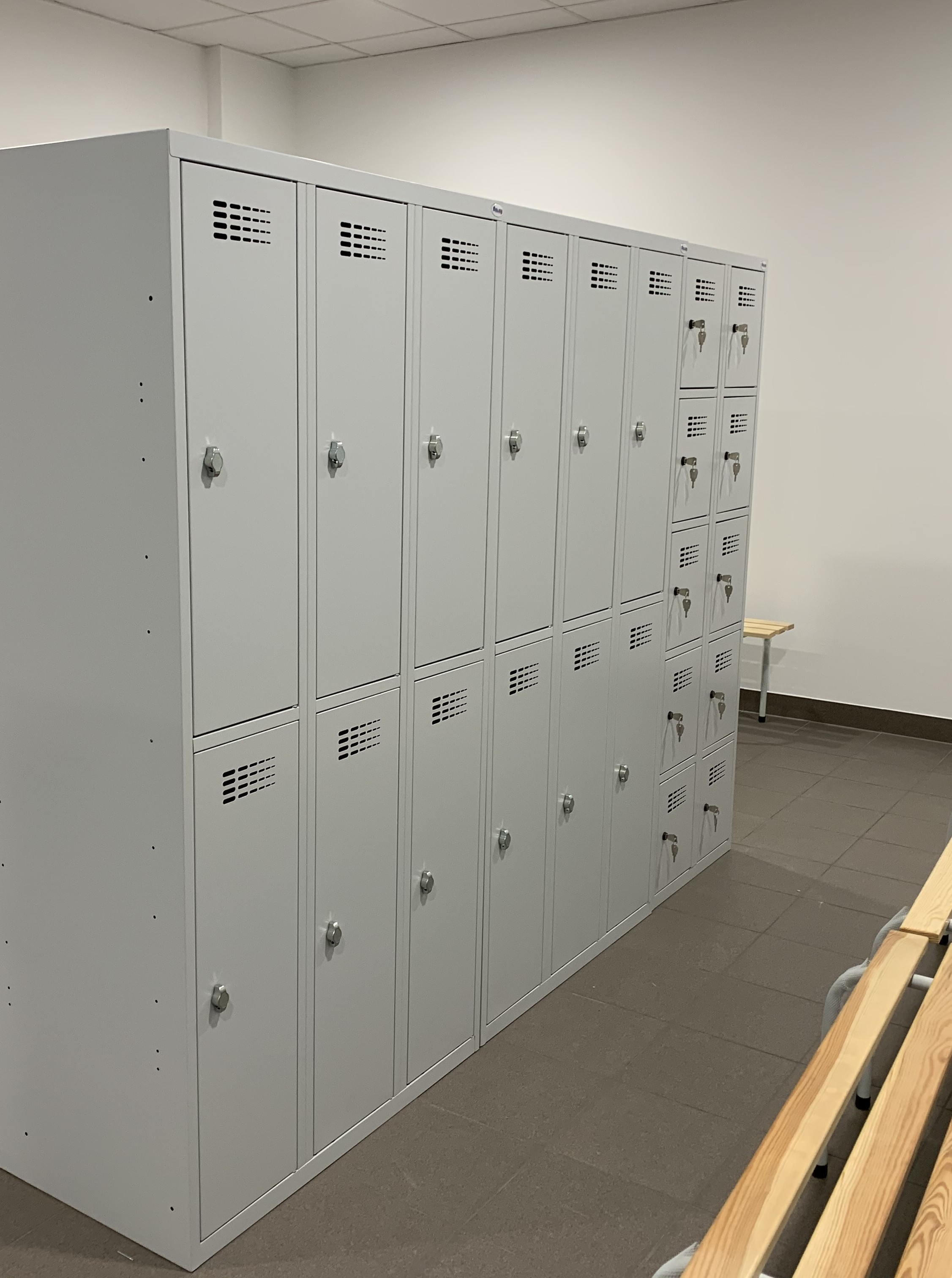 Metalowe szafy skrytkowe SUS 342 (6 skrytek) i SUS 325 (10 skrytek) z zamkiem na kłódkę oraz ławka szatniowa 120 cm, RAL 7035 – realizacja Pozmebel Poznań